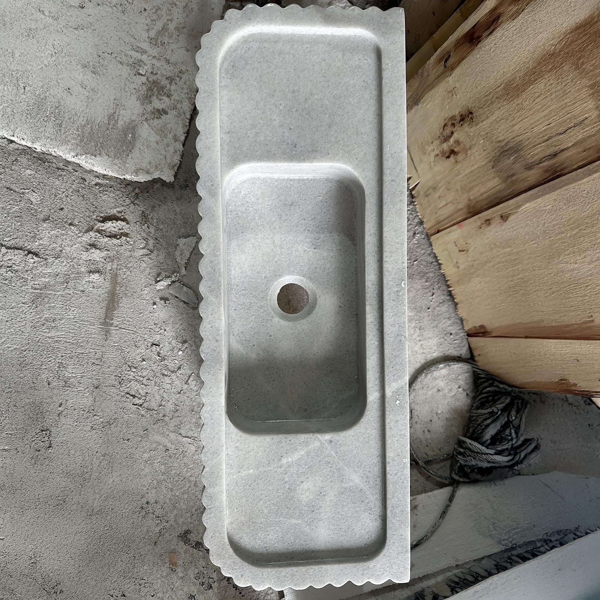 carrara marble sink with sculpted backsplash